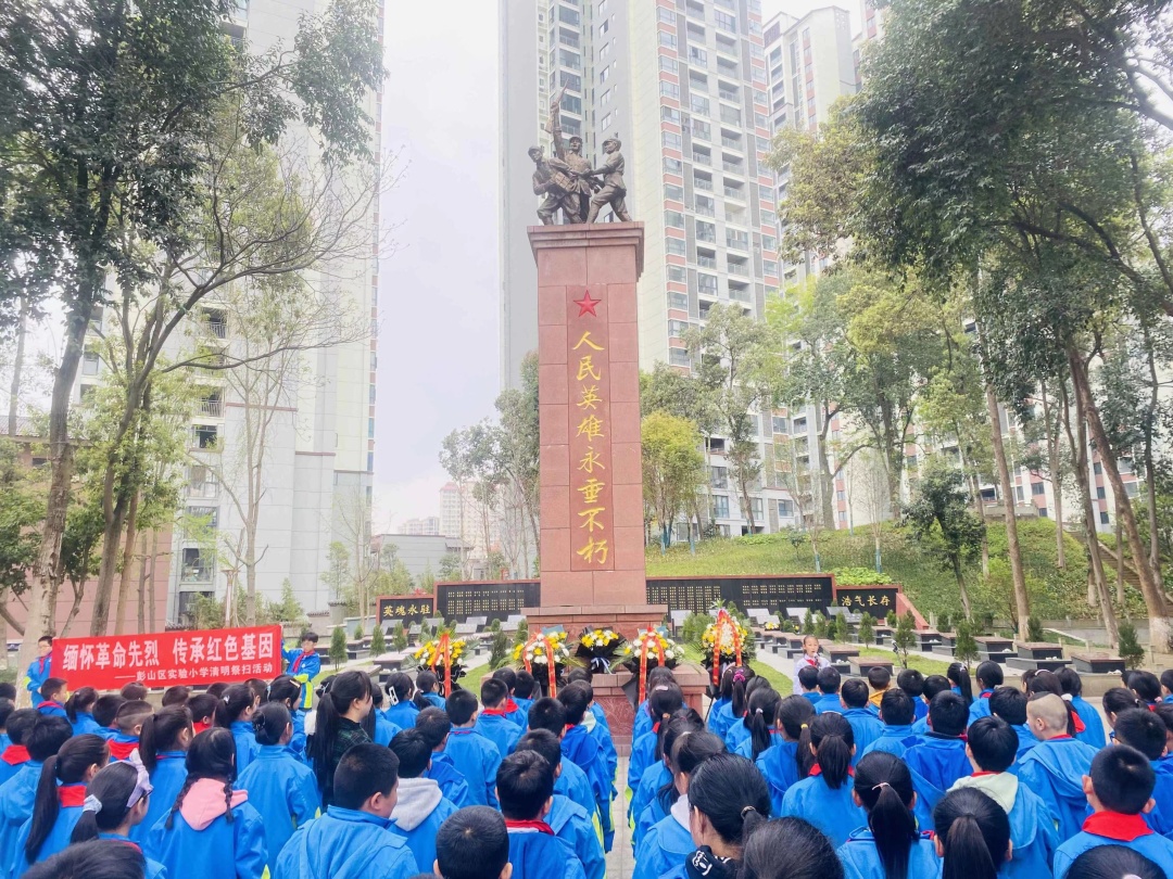 師生們在彭山區烈士陵園紀念碑前默哀。.jpg