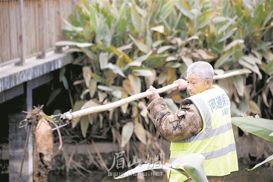 徐雙貴正在打撈河道雜物。.jpg
