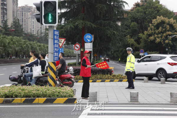 交警、交通志愿者共同維護(hù)交通秩序。